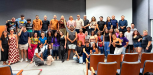 alunos no palco do auditório durante a recepção dos ingressantes de Letras Libras 2026.2